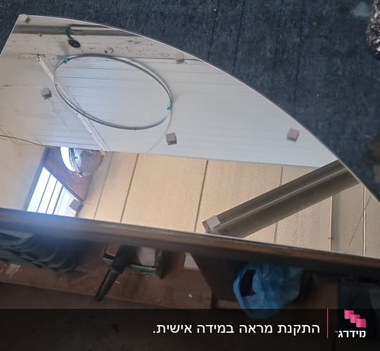 מראה בחיתוך מיוחד על שולחן עבודה בסדנת זגגות